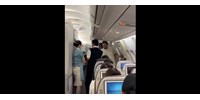 Videón, ahogy tízezer méter magasban próbálja kinyitni a repülő vészkijáratát egy agresszív utas